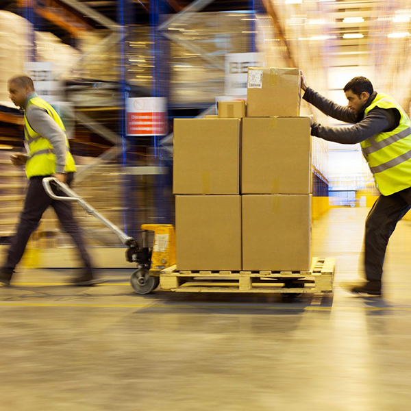 Workers rush by in a warehouse